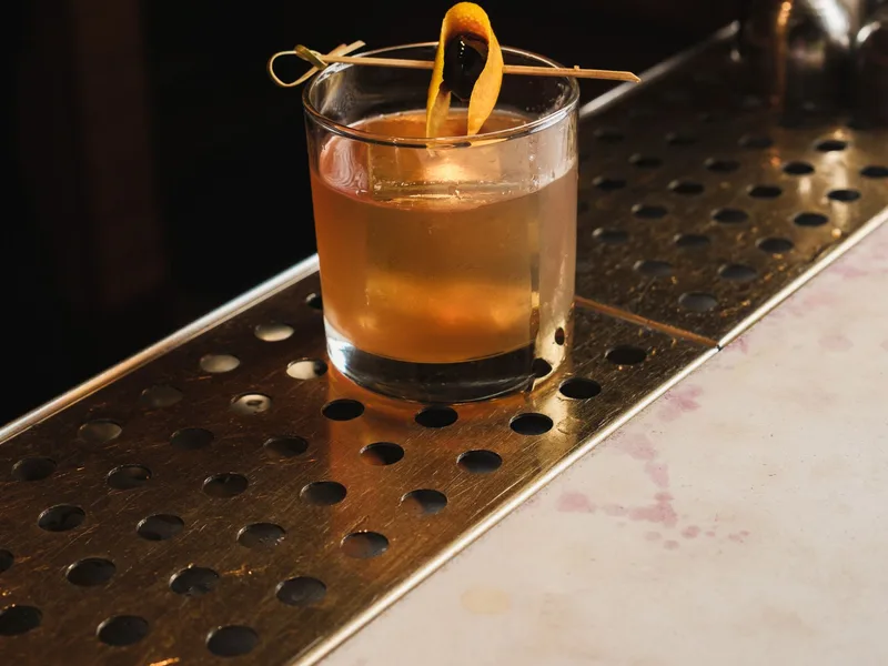 Bartender mixing a signature cocktail at Co.So bar in Pigneto